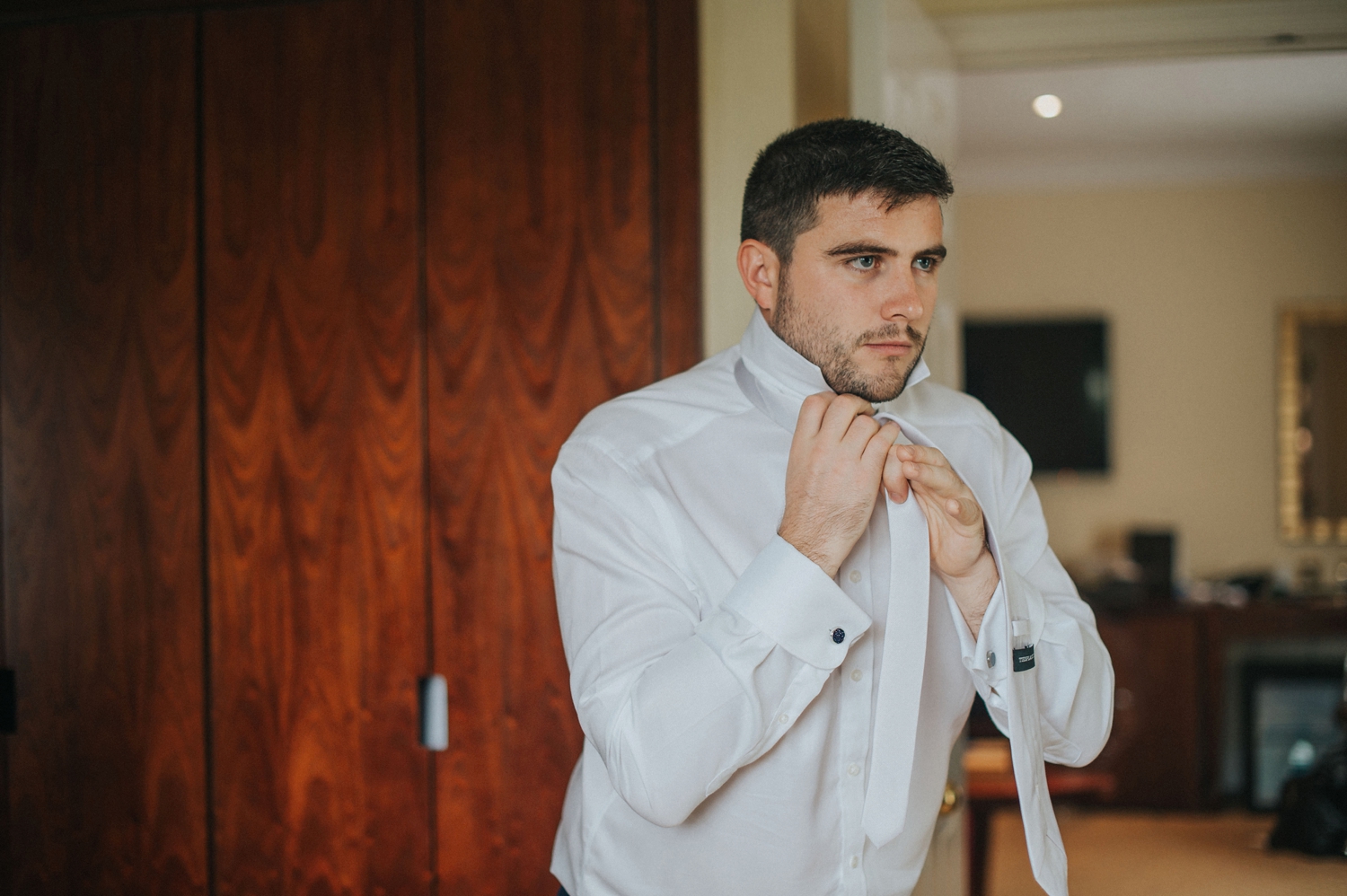 groom tying tie getting ready best wedding photographer