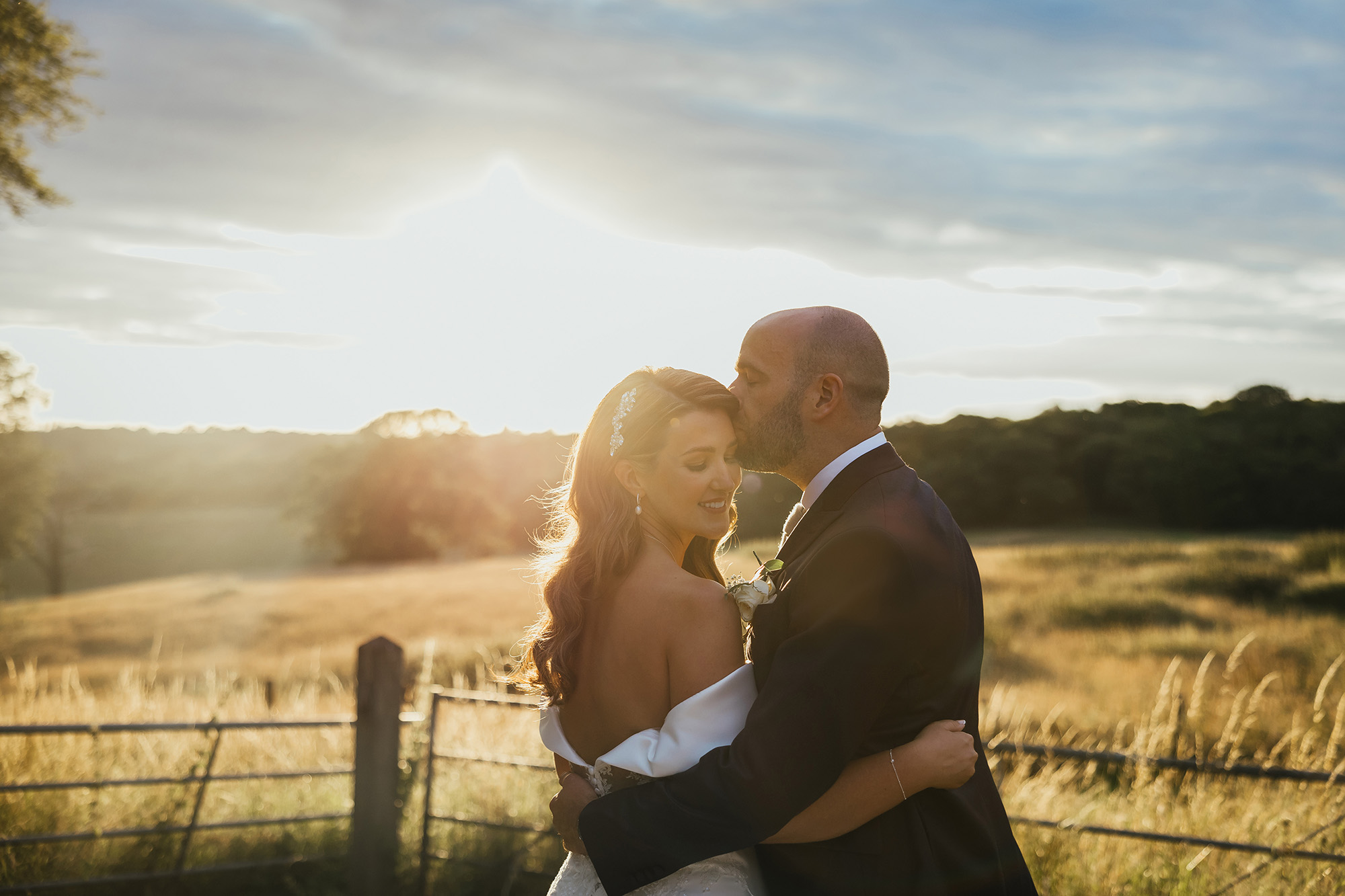 Bride and groom hugging at sunset at their Essex wedding